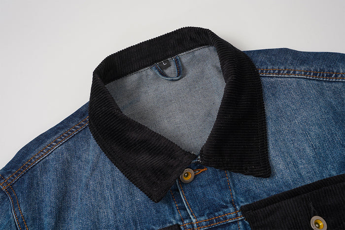 Close-up of a blue denim jacket neckline with a black ribbed corduroy collar and metal top button