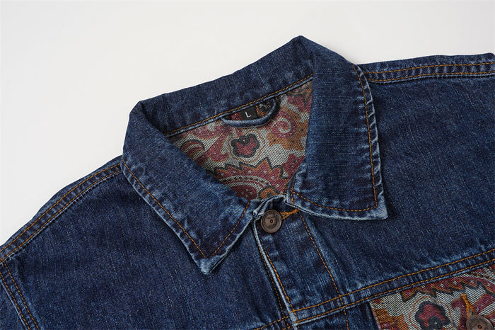 Close-up of the denim jacket collar showing paisley-patterned inner lining and button fastening