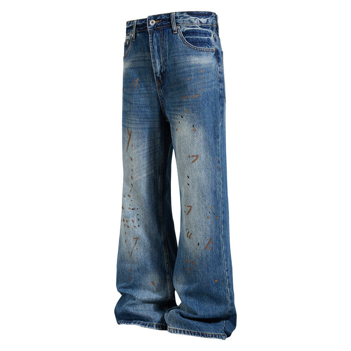 Angled front view of blue distressed flare jeans with faded knees and scattered paint splatters