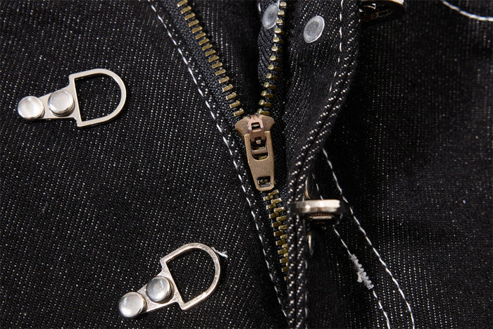 Close-up of the jeans fly showing a zipper, silver clasp hardware and white contrast stitching