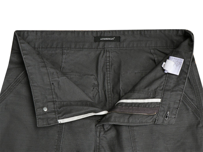 Inside waistband and open fly of dark gray cargo pants showing lining, zipper, button, and care label