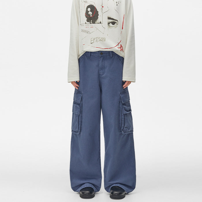 Front view of wide-leg blue cargo pants with multiple flap pockets and long relaxed legs