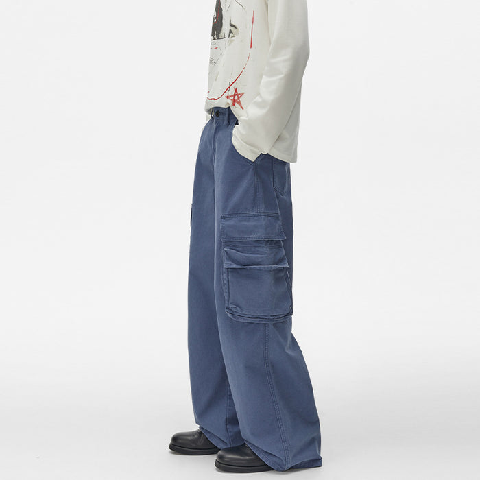 Side view of blue wide-leg cargo pants showing layered flap pockets and straight outer seam