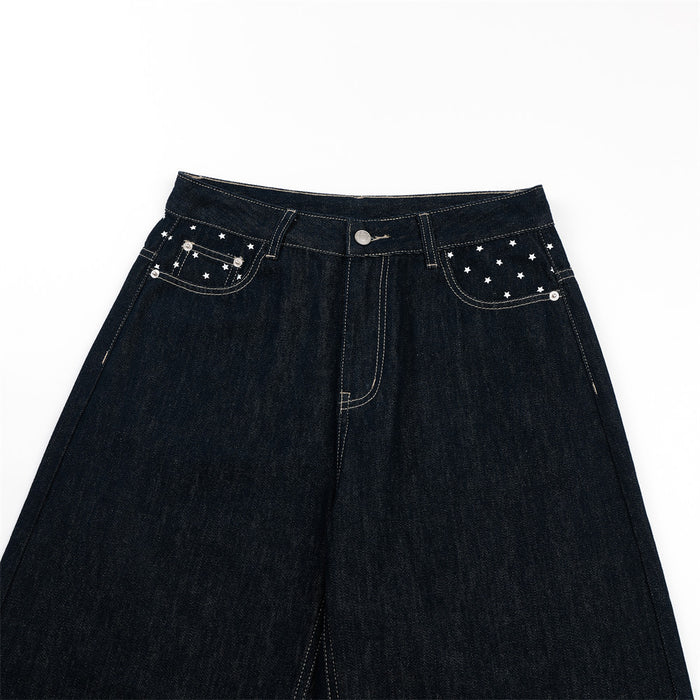 Front upper view of dark indigo wide-leg jeans showing star-patterned front pockets and button closure