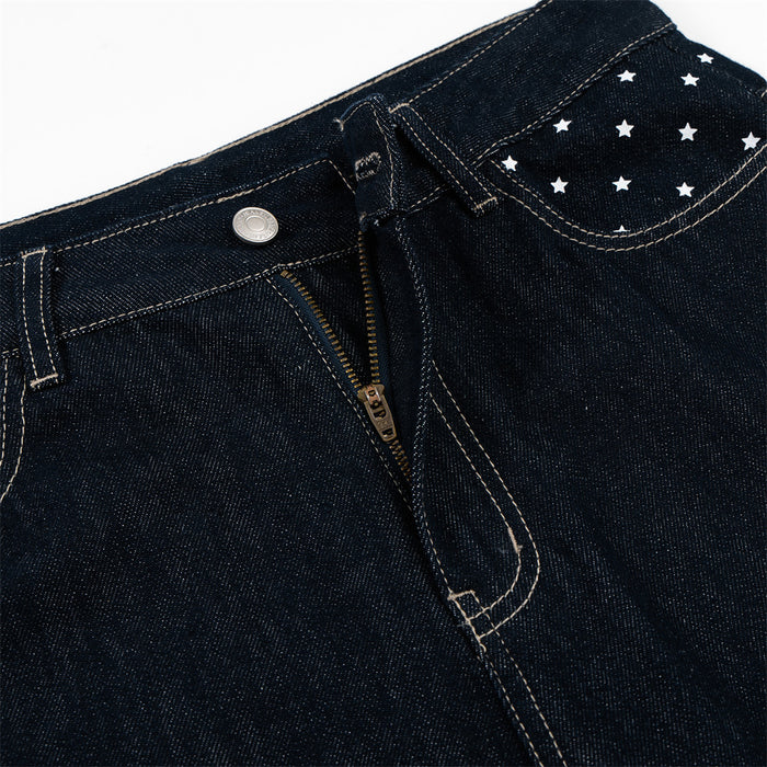 Close-up of dark indigo jeans waistband, button, zipper fly, belt loop, and star-patterned front pocket