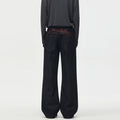 Men's black wide-leg raw denim jeans with red music note embroidery on back waistband, straight fit full-length view