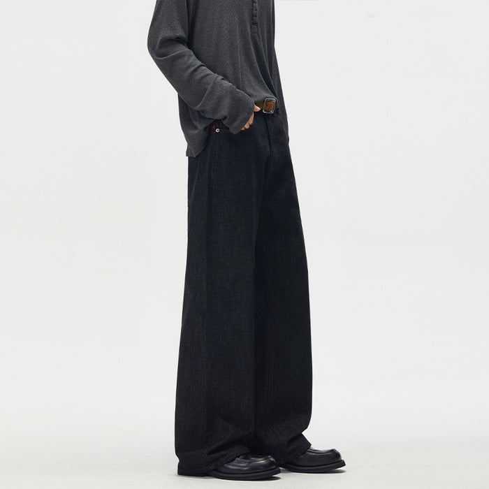 Profile view of black wide-leg denim jeans showing the full-length loose leg and dark textured denim