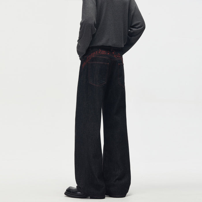 Back view of black wide-leg jeans showing two patch pockets and red musical note stitching across the yoke