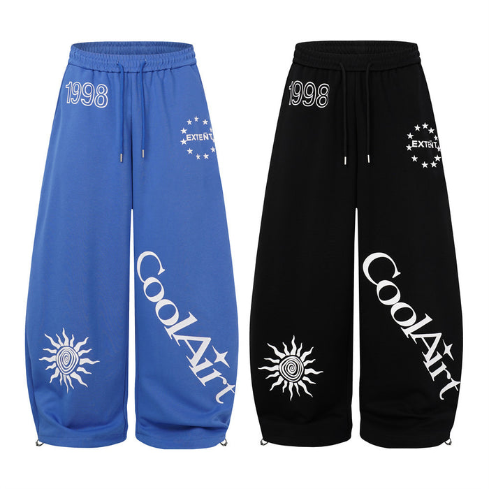 Front view of blue and black wide-leg sweatpants with white 1998, star, sun, and CoolArt graphics