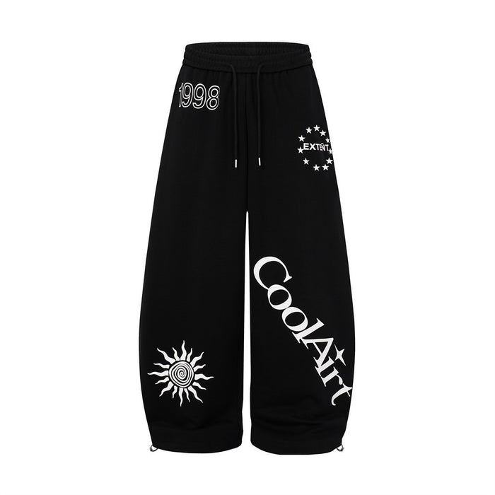 Men's wide-leg graphic sweatpants in black with CoolArt letter print, star emblem, and sun motif on baggy streetwear silhouet