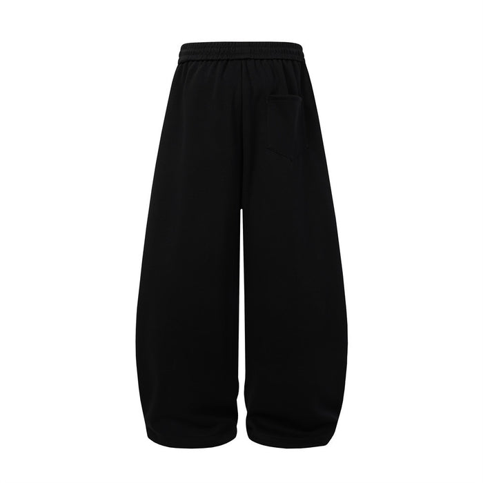 Back view of black wide-leg sweatpants showing an elastic waistband and single rear pocket