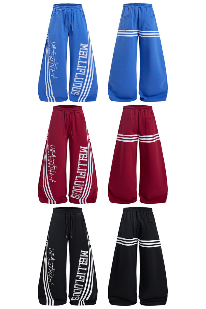 Front and back views of blue, burgundy, and black wide-leg sweatpants with white stripe bands