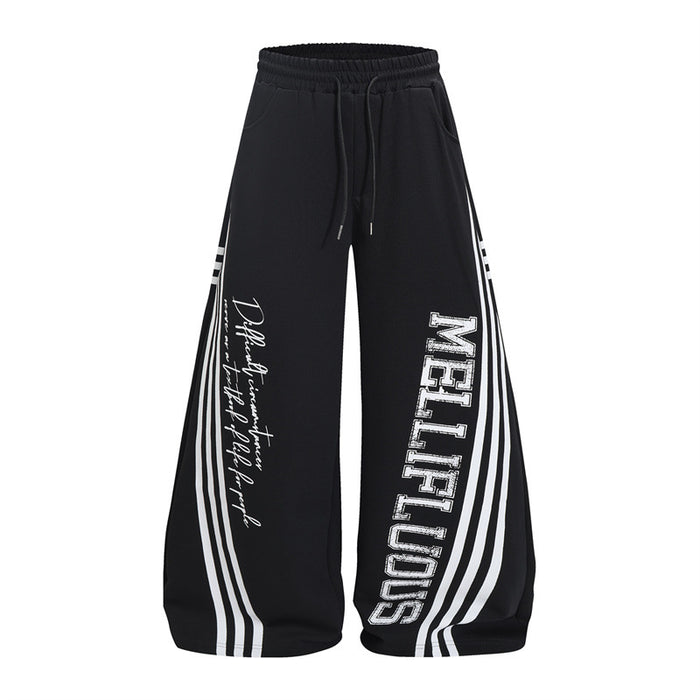 Black wide-leg sweatpants front with triple white side stripes, MELLIFLUOUS lettering, and cursive text