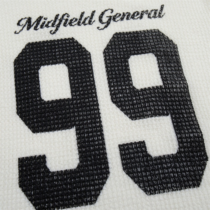 Close-up of black 99 numerals and Midfield General script embroidered on white waffle-knit fabric