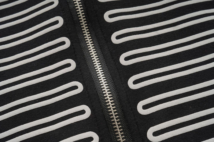 Detailed view of the silver front zipper between repeated white horizontal braid loops