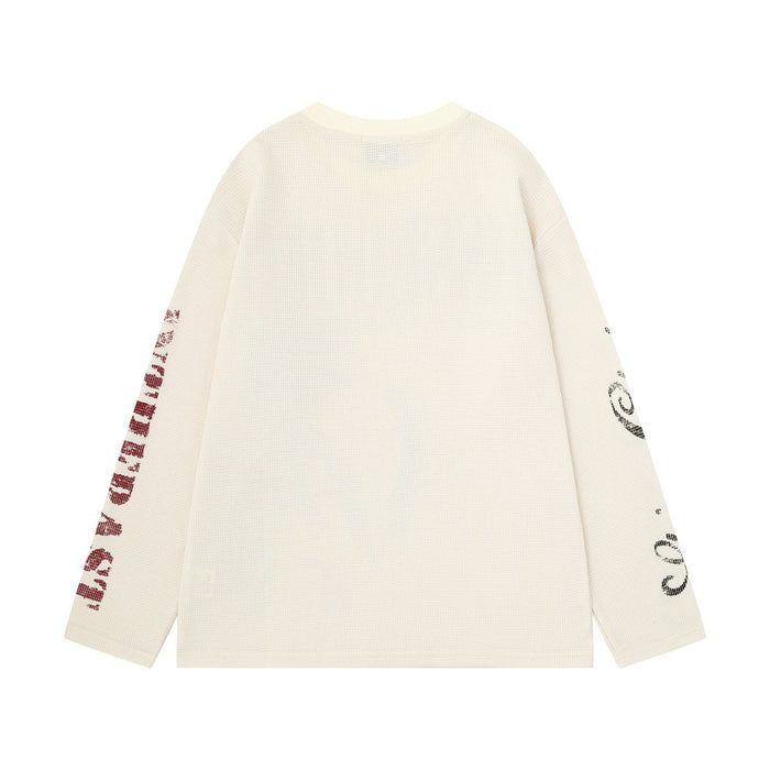 Cream waffle-knit shirt back showing a plain body with printed graphics along both sleeves
