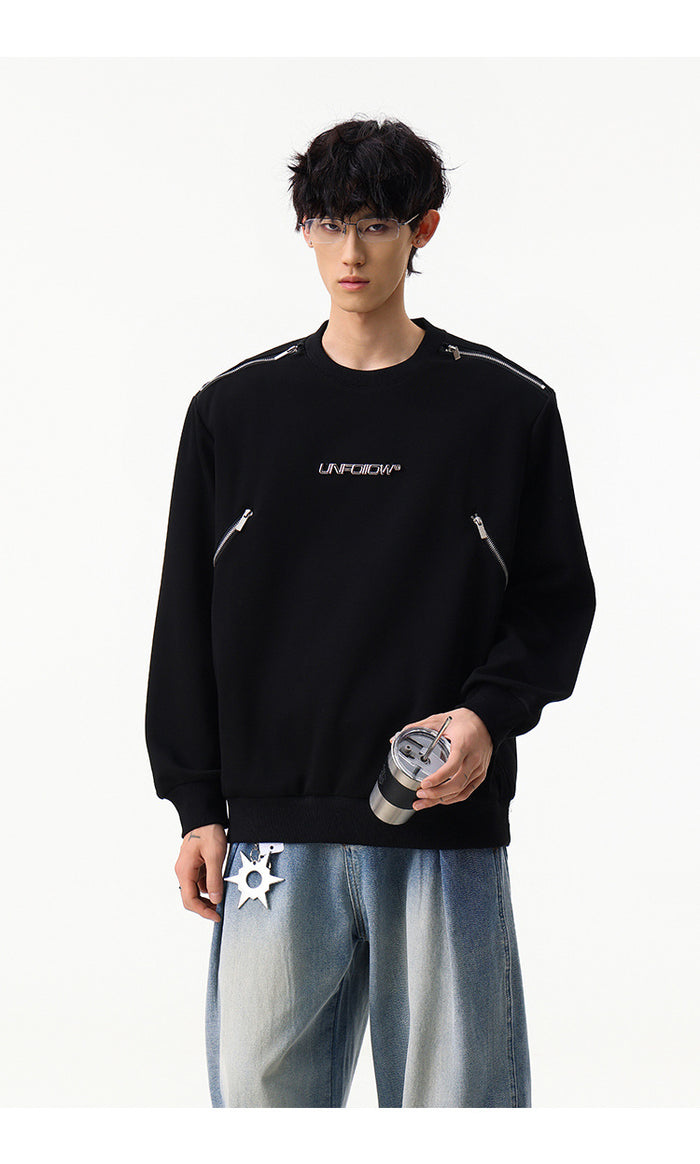 Front view of a black crew neck sweatshirt with silver shoulder zippers and angled zip pockets on a model