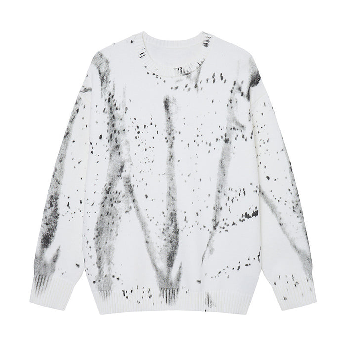 Oversized crewneck knit sweater with all-over black ink-wash and paint splatter print on white base, front view