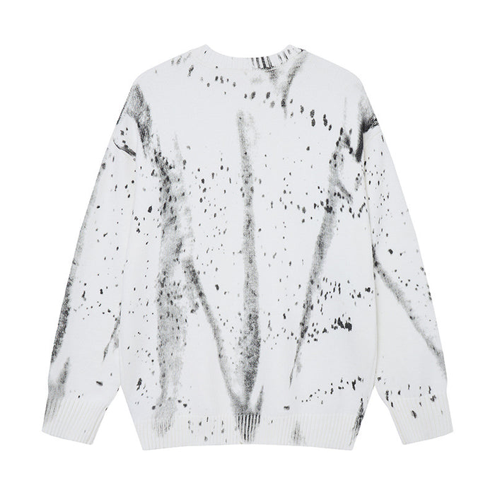 White knit crewneck sweater with gray and black paint-splatter streaks, shown from the front