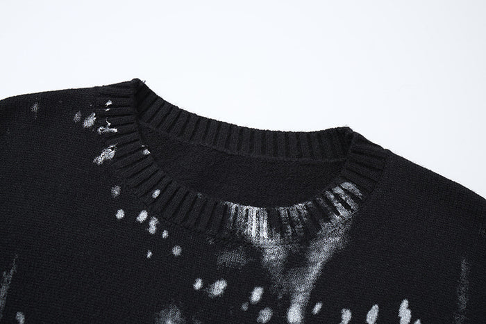 Close-up of the black sweater’s ribbed crew neckline with gray streaks and white speckles