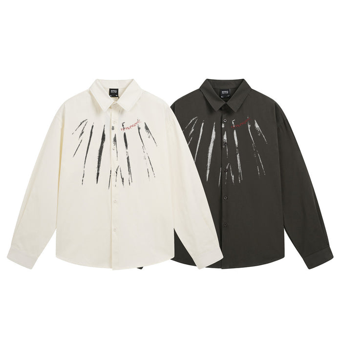 Two long-sleeve button-up shirts in cream and black, each featuring white paint-stroke graphics across the chest