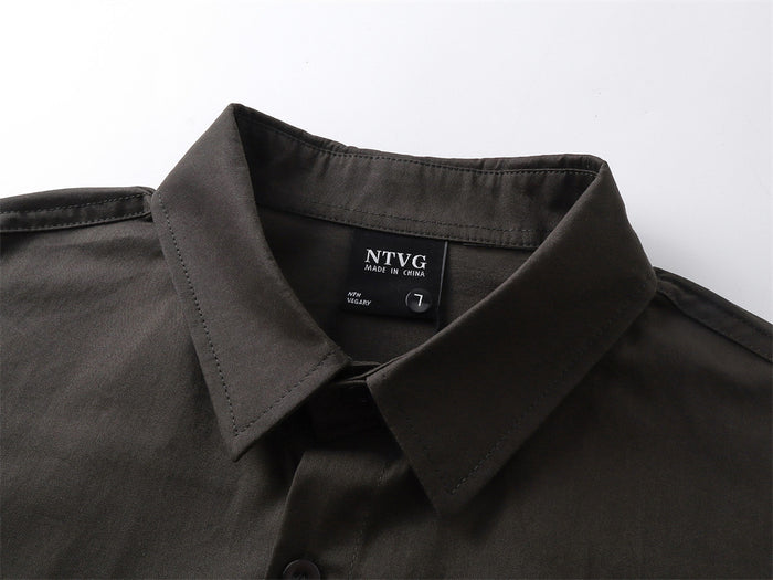 Close-up of the black shirt's pointed collar, inner label, stitching, and top button placket