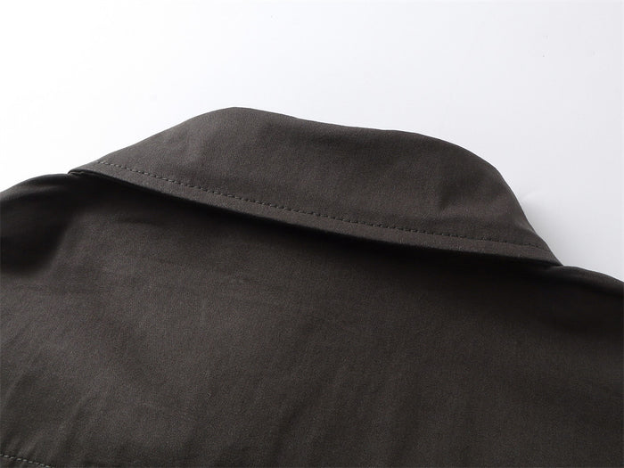 Close-up of the black shirt collar showing its folded edge, stitching, and textured fabric