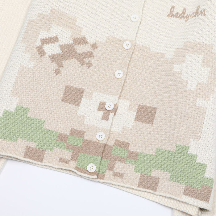Close-up of the cream cardigan's pixel bear pattern, white buttons, and green and beige jacquard knit details