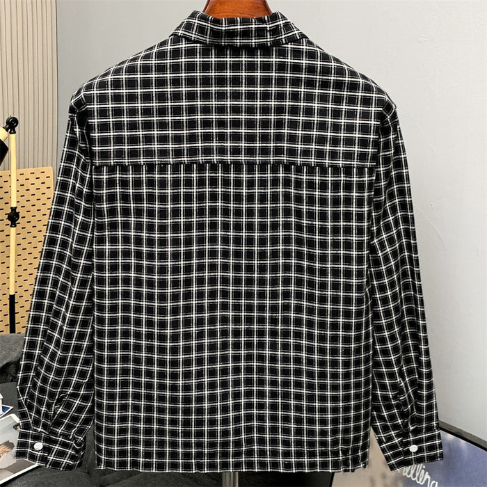 Back view of a black plaid long sleeve shirt on a hanger, showing yoke seam and buttoned cuffs