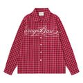 Front view of a red plaid long sleeve shirt with white cursive chest embroidery and white buttons