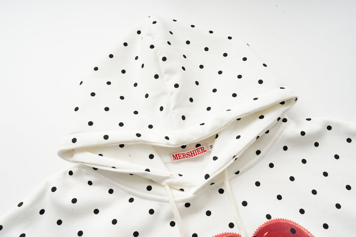 Close-up of the cream polka dot hoodie hood, showing the inner seam, drawstrings, and sewn label