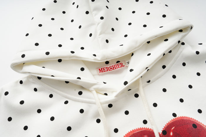 Detailed view of the polka dot hood with drawstrings, inner label, and the top of the red heart graphic