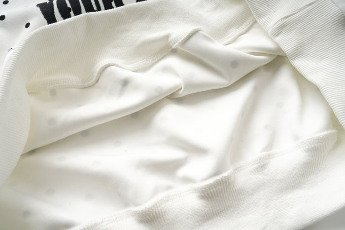 Close-up of the hoodie’s soft cream interior lining and ribbed cuff, showing the fabric texture