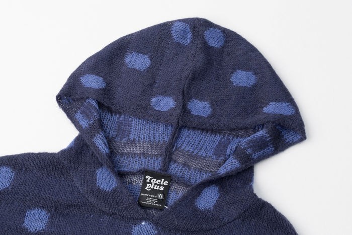 Close-up of the navy hoodie showing its polka dot hood, knit texture, and sewn neck label