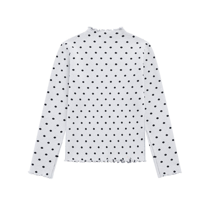 Back view of a white polka dot knit sweater with long sleeves and ruffled trim