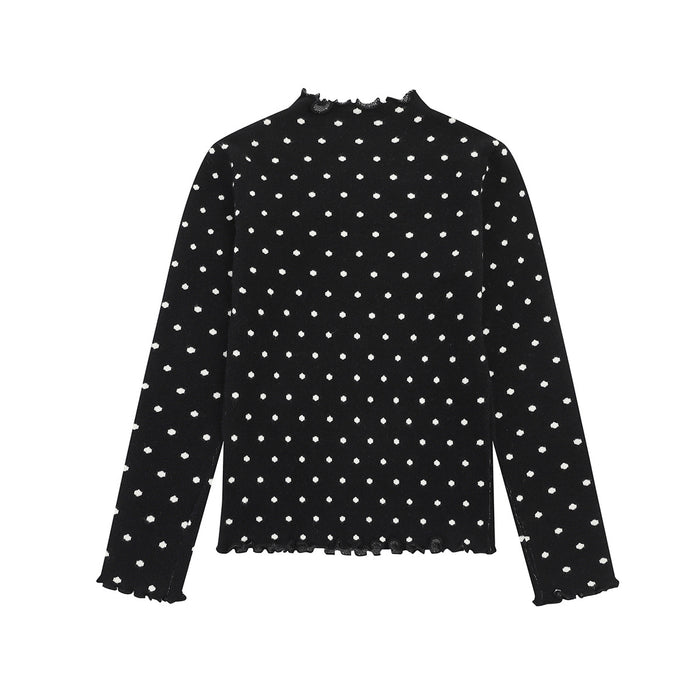 Back view of a black polka dot mock neck sweater with long sleeves and ruffled hem