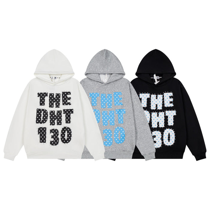 Three oversized hoodies in white, gray, and black with bold polka dot letter graphics and rhinestone accents