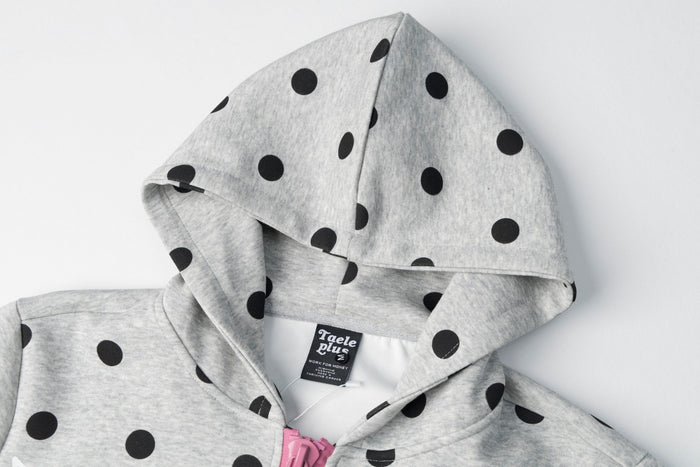 Close-up of the gray polka dot hood showing its structured shape, seam, and sewn label