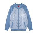 Front view of a light blue knit zip-up cardigan with polka dots, stars, music notes and white script