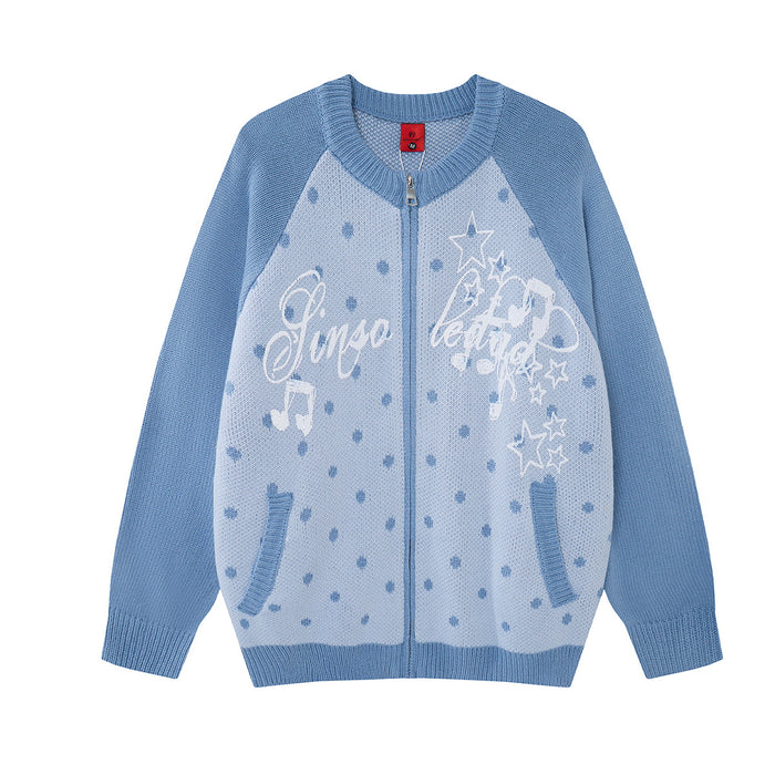 Front view of a light blue knit zip-up cardigan with polka dots, stars, music notes and white script