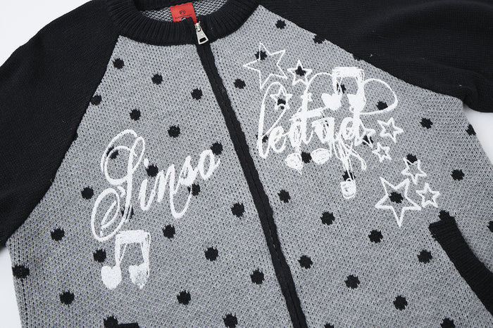Close-up of the black and gray cardigan front with white script, stars, music notes and black polka dots