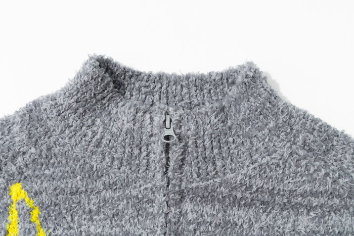 Close-up of the gray sweater collar and metal zipper in soft bouclé knit texture