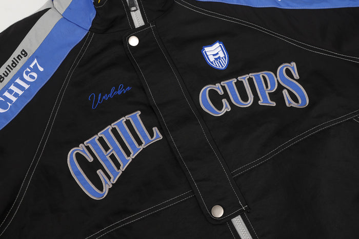 Close-up of black jacket chest embroidery featuring CHILL CUPS lettering and a shield patch