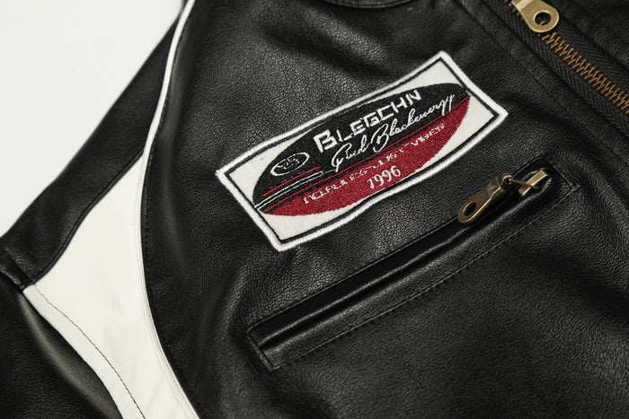 Close-up of the jacket chest patch with burgundy detail beside a black zippered pocket and white side panel
