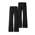 Raw black denim jeans shown front and back, with a row of side snap buttons along both outer legs