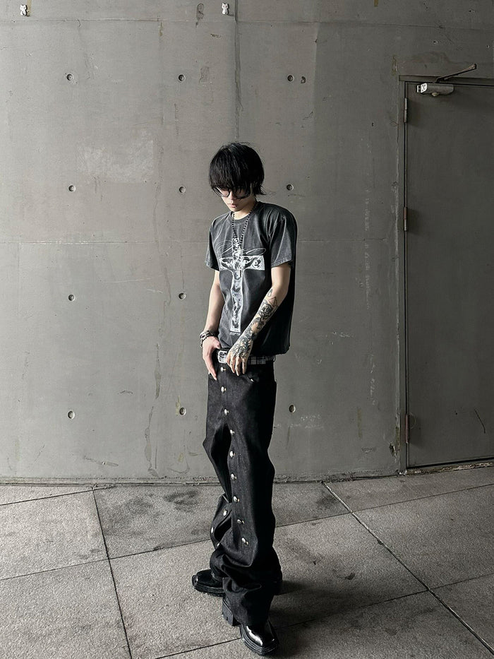 Side model view of black straight-leg jeans showing the relaxed fit and outer-leg snap closure