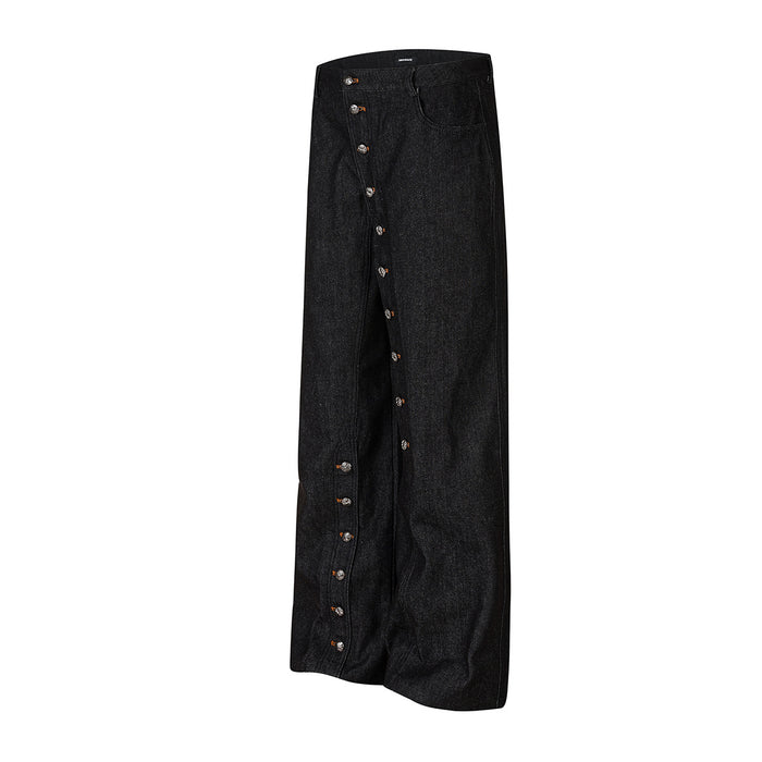 Front view of black denim jeans with silver snap buttons extending from the waist down both outer legs