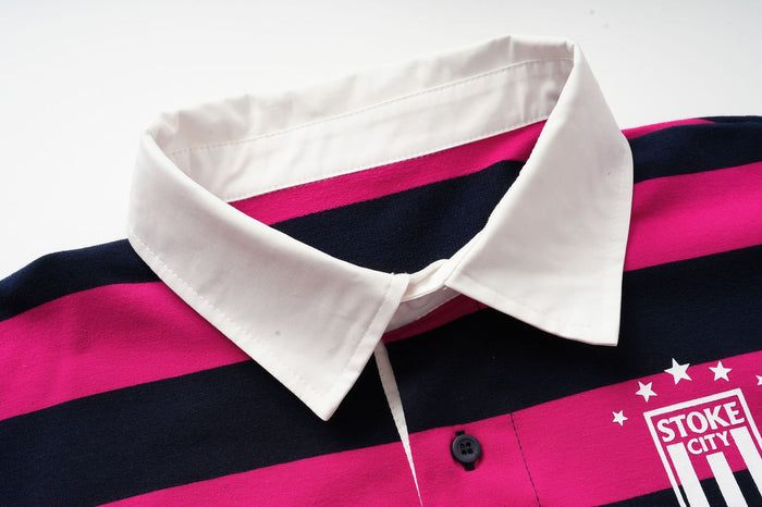 Close-up of the white polo collar, button placket, and chest crest on hot pink and navy striped fabric