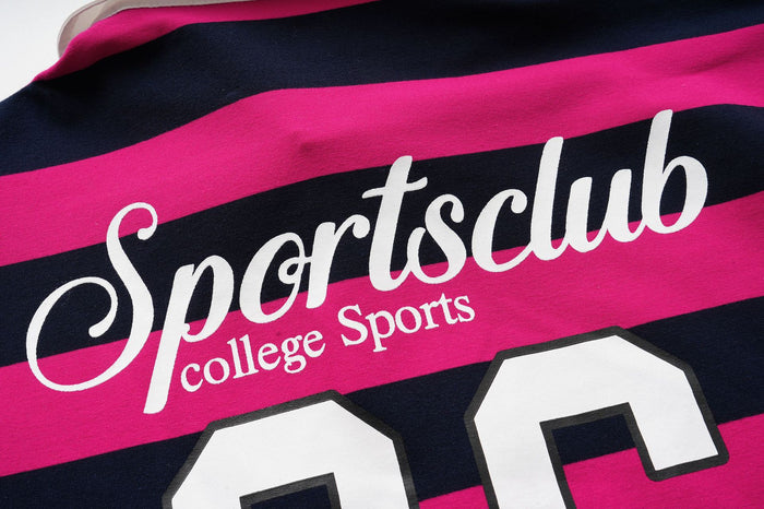 Close-up of white Sportsclub College Sports lettering above the large number on hot pink and navy striped fabric