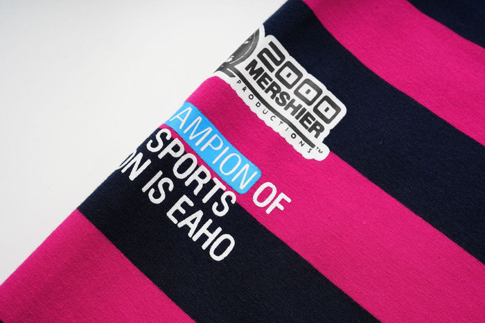 Close-up of a sleeve print reading Champion of Sports N S Eaho beside a black and white graphic label